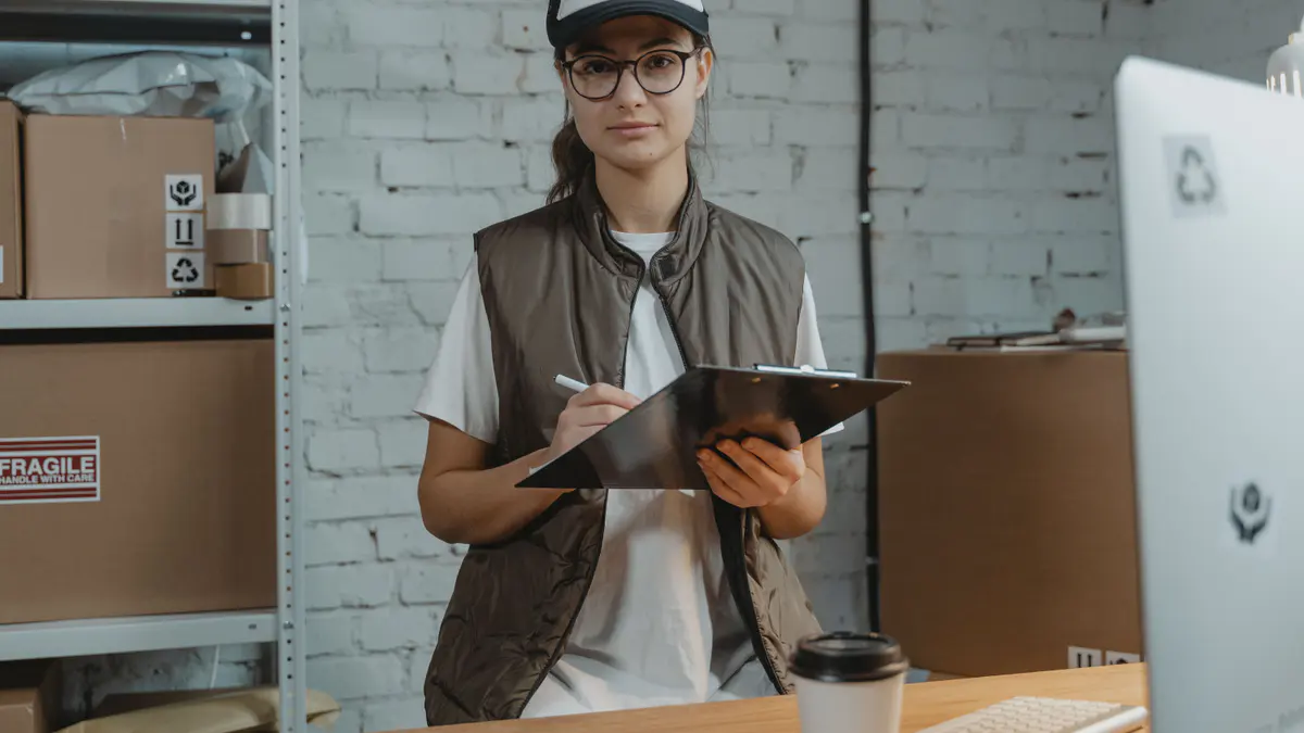 Warehouse employee recording shipment information on a clipboard