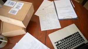 Shipping boxes, paperwork and a laptop used to plan an overseas order